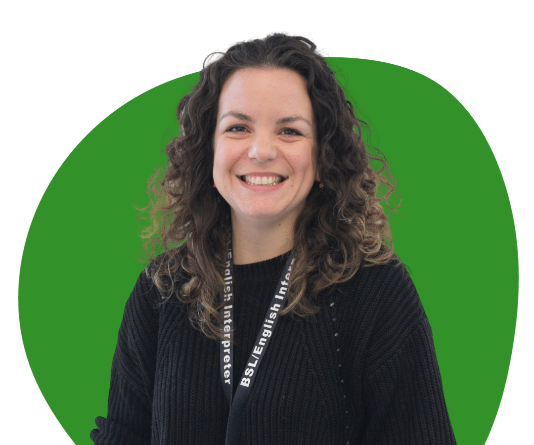 White woman with long, brown, curly hair against a dark green background.