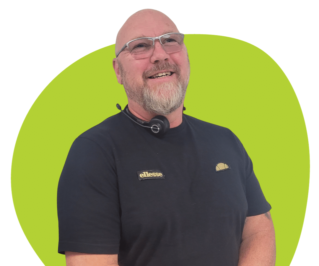White man with glasses and a beard against a light green background.
